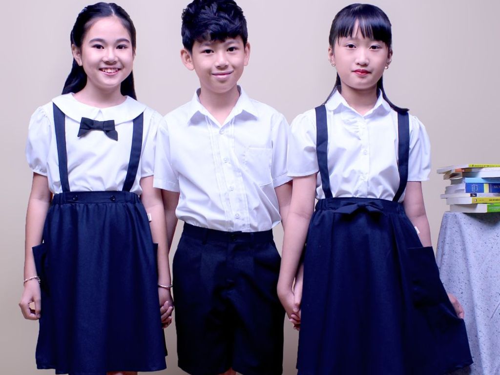 Set đồ bao gồm một chiếc váy yếm được mặc bên ngoài áo sơ mi đơn giản
