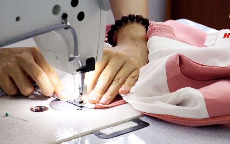 Bạn cần khéo léo may ráp phần bo đã thu nhỏ vào thân áo và tay áo