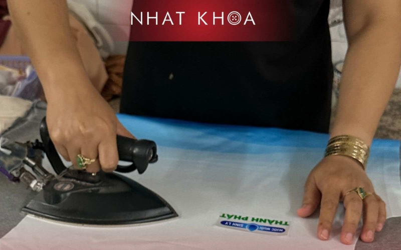 Nhat Khoa carefully presses uniforms before delivery.