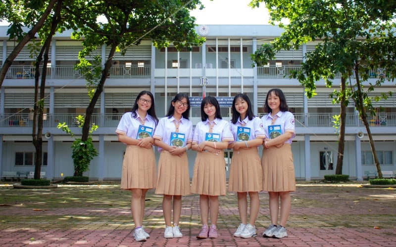 Đồng phục Võ Trường Toản dành cho nữ gồm sơ mi trắng và váy xếp ly màu be ấm